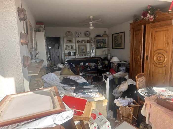 Salon encombré avant un débarras et un nettoyage en profondeur à Marseille.