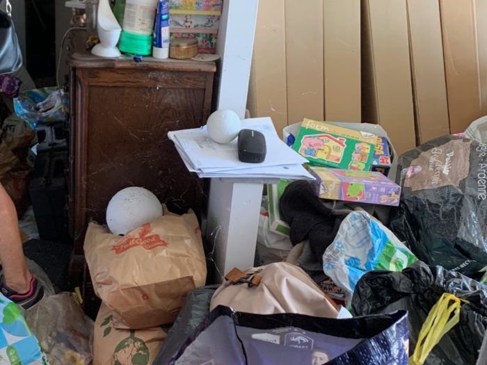Salon encombré nécessitant un nettoyage et un débarras en raison du syndrome de Diogène.