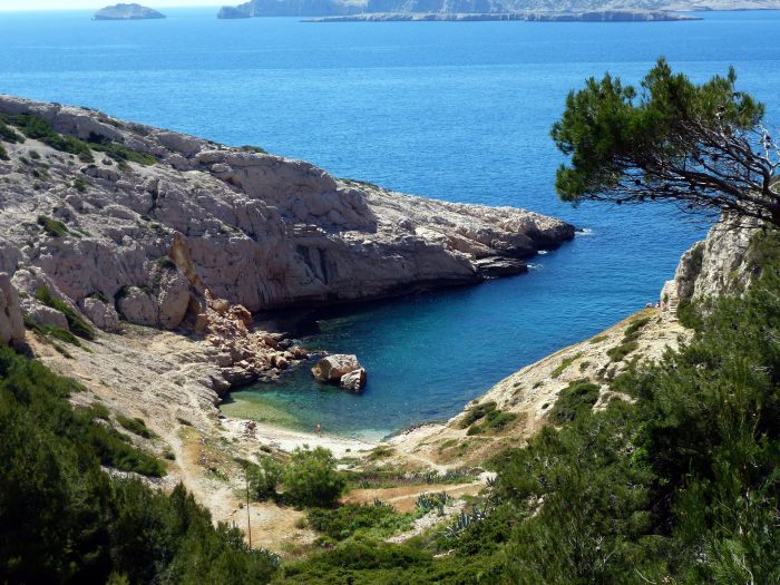 Calanque de Marseille avec ses falaises rocheuses, sa plage et la mer turquoise.